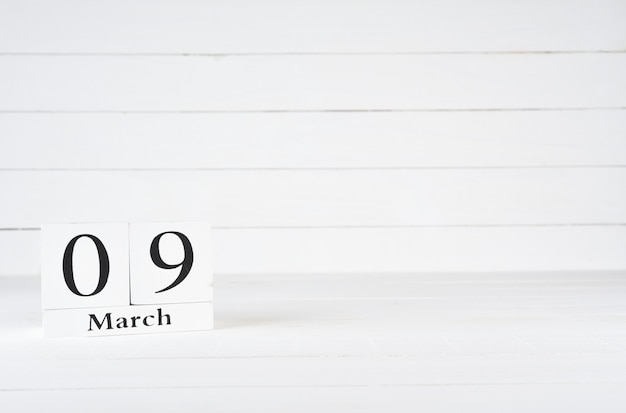9 maart, Dag 9 van de maand, Verjaardag, Verjaardag, houten blokkalender op witte houten achtergrond met exemplaarruimte voor tekst.