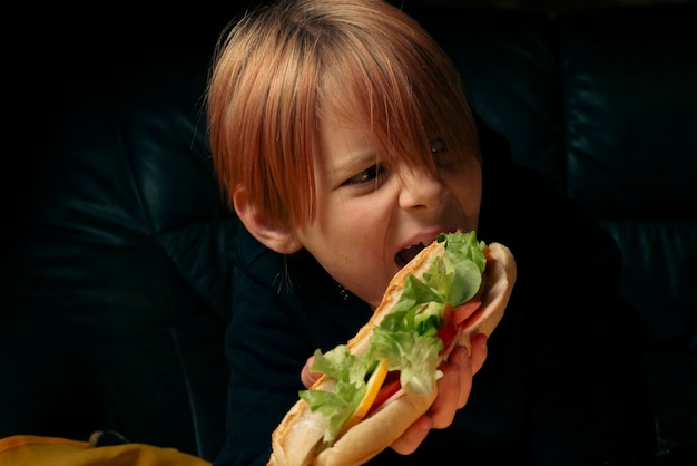 9 year old boy eating a big baguette sandwich