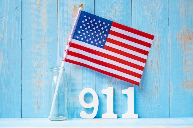 911 text and United States of America flag on wooden table background Patriot Day September memorial and Never Forget concept