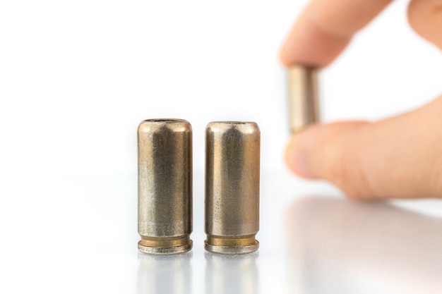 9mm bullets isolated on a white background, hand with bullet shell