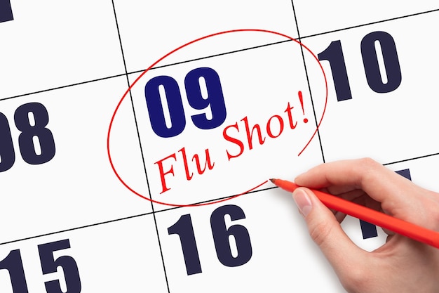 매월 9일 손으로 텍스트 FLU SHOT을 작성하고 달력 날짜에 동그라미를 칩니다.