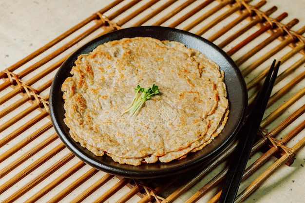 Foto 검은색 접시에 담긴 한국 음식 메밀전 부침개 요리