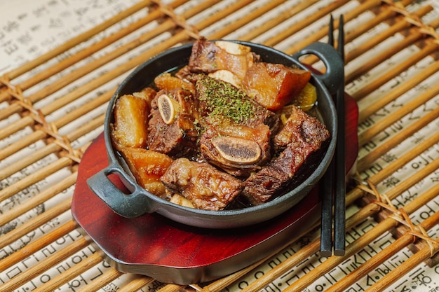 Photo 검은색 접시에 담긴 한국 음식 갈비찜 요리