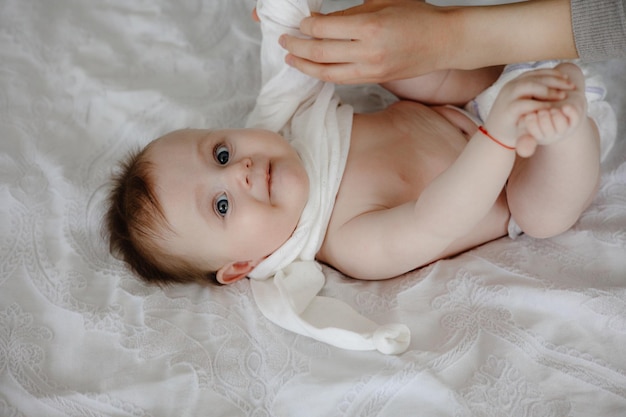 写真 赤ちゃんが「赤ちゃん」と書かれた白いタオルをかぶっている