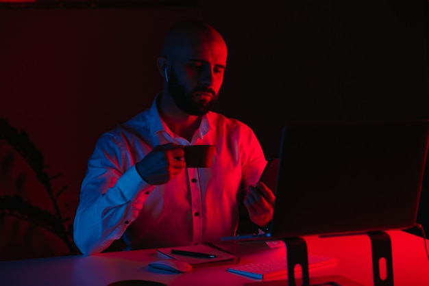 Фото Лысый мужчина с бородой удаленно работает на ноутбуке дома