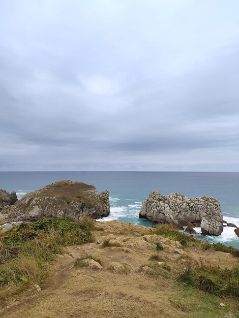写真 背景に岩と海があるビーチシーン