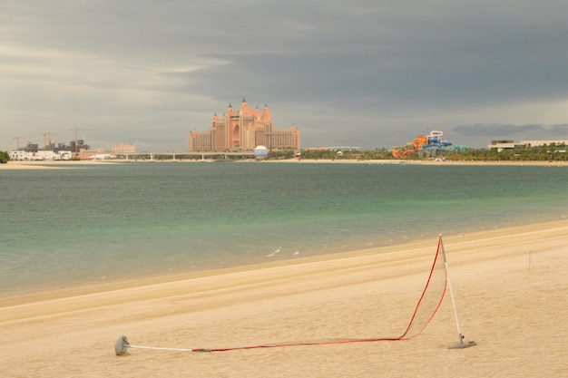 写真 背景に赤いロープと建物があるビーチ