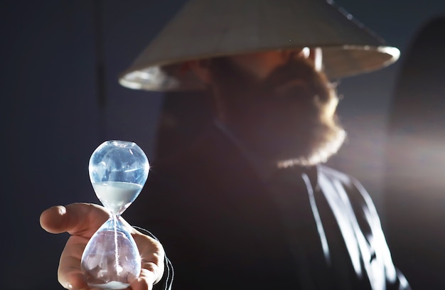 Фото Бородатый мужчина в костюме держит в руке какой-то предмет. понятие времени и идей. стремление и развитие.