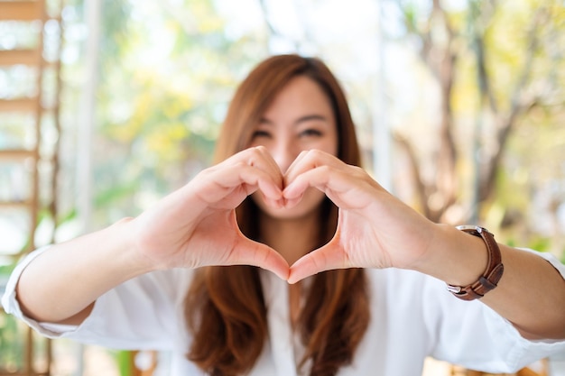 写真 幸せな気持ちでハートの手サインを作る美しいアジアの女性