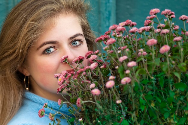 写真 美しい少女は、花の大きな花束を持って、街で幸せな若い女性を笑顔にしています