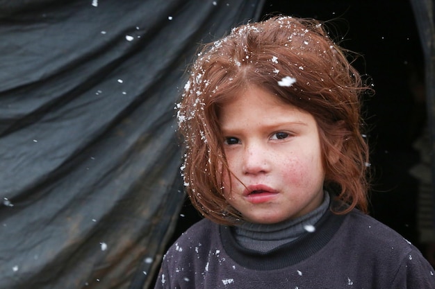 写真 トルコ国境近くのシリアの難民キャンプで雪が降る美しい難民の女の子