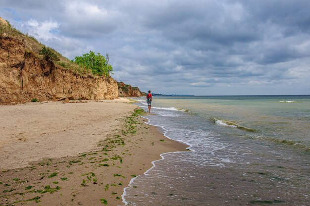 Фото Красивый морской пейзаж с крутым высоким берегом из красной глины и красивым небом