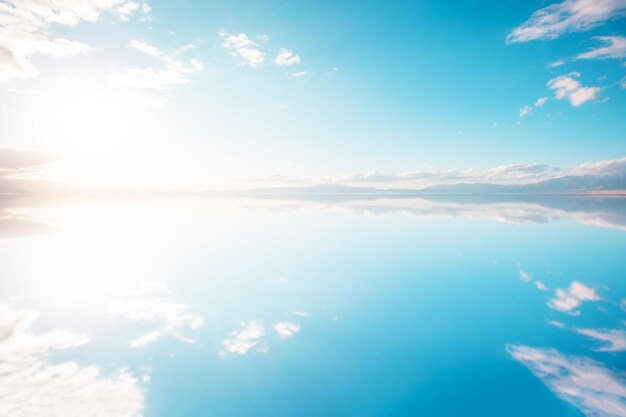 写真 雲と太陽が水に反射する青い空
