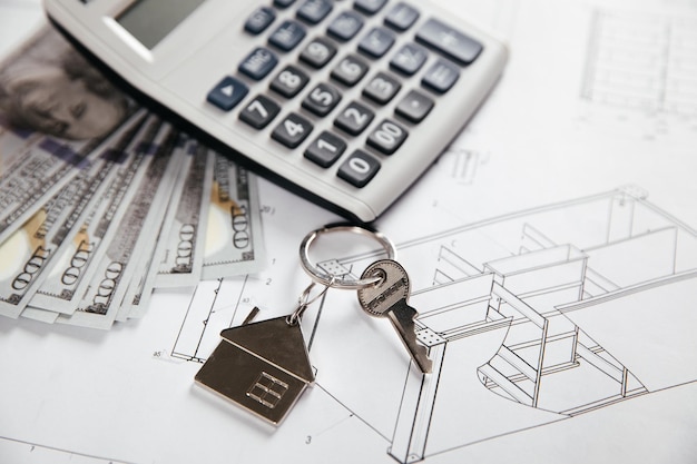 Фото План архитектора с калькулятором денег и ключом от дома стоимость строительства нового дома