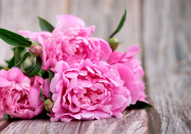 写真 明るい木製の背景にピンクの牡丹の花束をクローズアップ