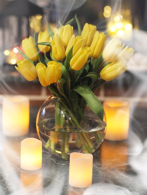 복고풍 방의 내부에 있는 꽃병에 노란 튤립 꽃다발. 튤립의 부케와 레트로 인테리어입니다.