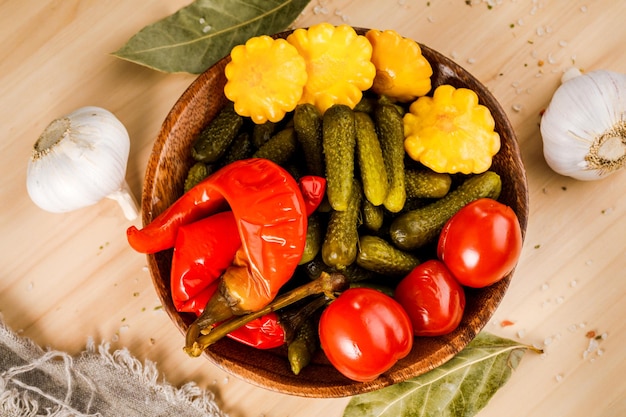 Фото Миска маринованных овощей на деревянном столе. соленья