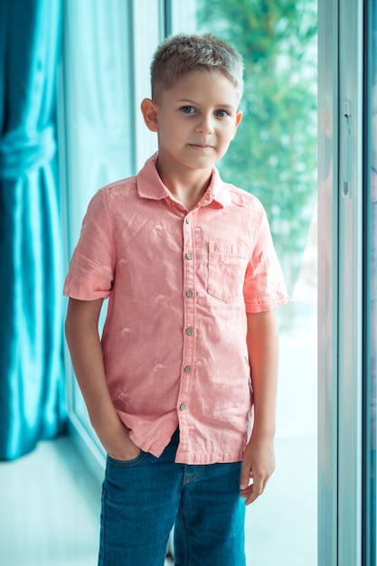Фото Мальчик в модной льняной рубашке и джинсах позирует