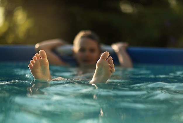 写真 夏の暑さの中で男の子がプールで泳ぐ