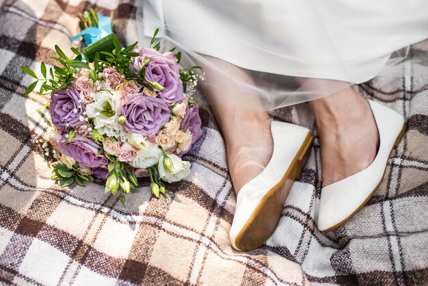 写真 花嫁は花束を持って格子縞の毛布に座ります