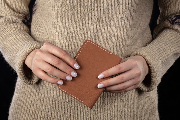 写真 茶色の革の財布は女性の手にあります