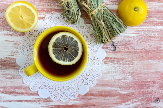 Фото Букет из сухого лимонника, свежего лимона и чашка чая.