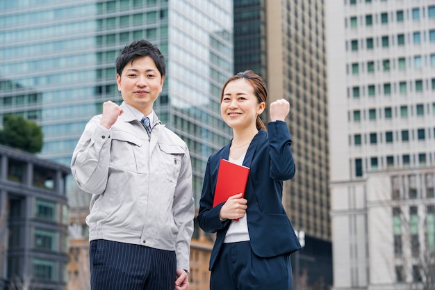 写真 作業服を着たビジネスマンとスーツを着たビジネスウーマン