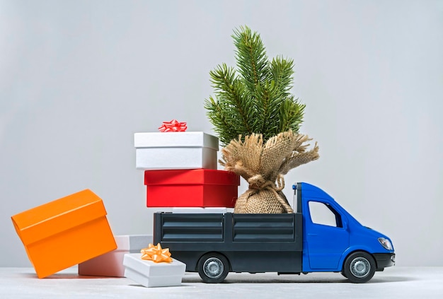 Фото Грузовой грузовик перевозит рождественскую елку и коробки с подарками