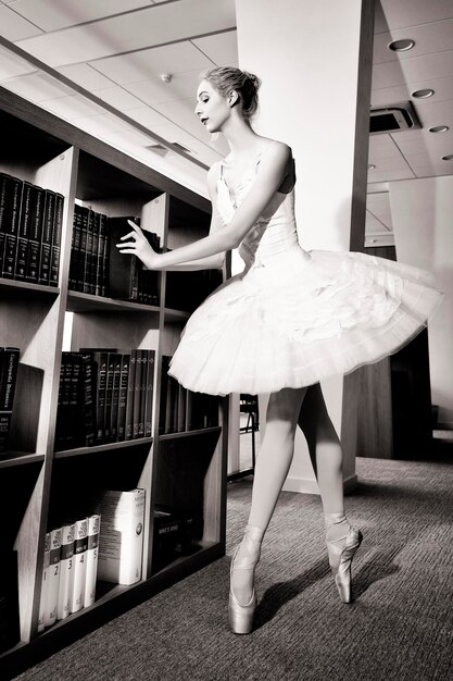Фото Очаровательная балерина пошла в библиотеку, чтобы выбрать новую книгу во время перерыва