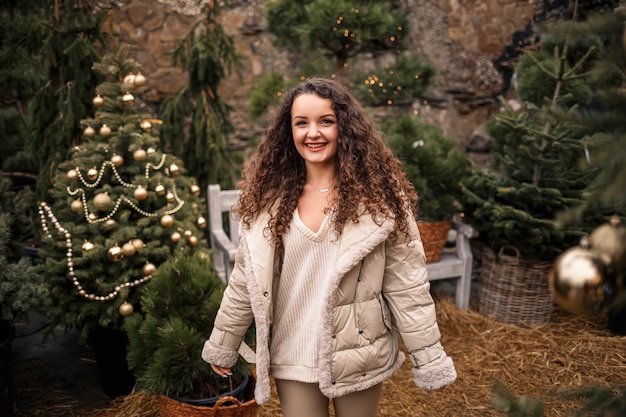 Фото Веселая девочка гуляет среди деревьев и улыбается, у нее новогоднее настроение