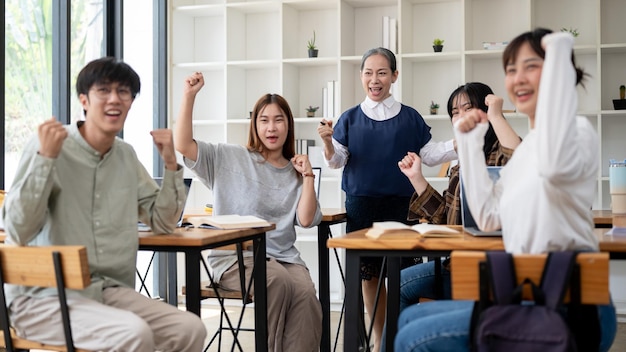 사진 즐거운 성숙 한 아시아 여성 교사 는 학생 들 과 함께 좋은 소식 을 축하 하는 주먹 을 보여 준다