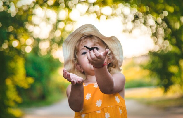 Фото Ребенок ловит бабочку в природе с выборочной фокусировкой