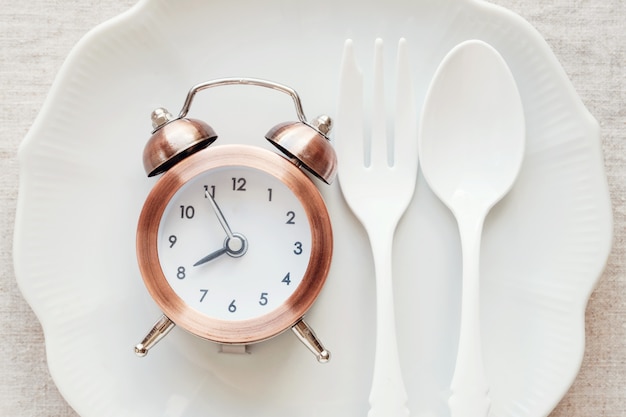 写真 プレート上の時計、断続的な空腹時の食事療法の概念
