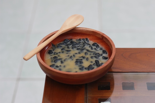Фото Крупный план миски с традиционным индонезийским напитком под названием dawet ireng или черный dawet индонезийская традиционная пища фотоконцепция