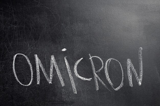 写真 黒板に白いチョークで書かれたオミクロンという単語のクローズアップ