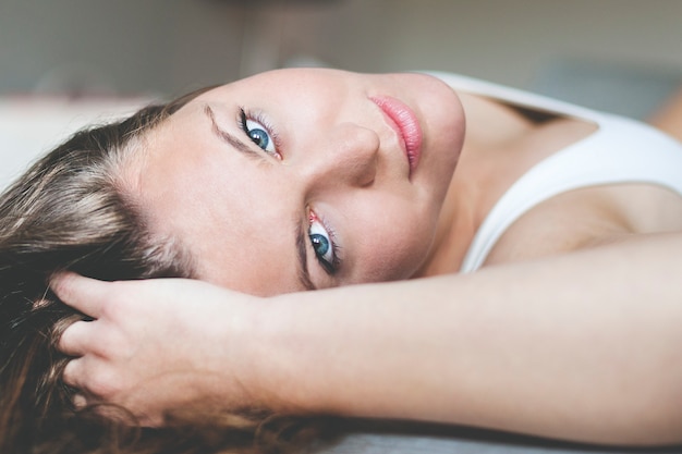 A close up van een jonge vrouw tot op een divan