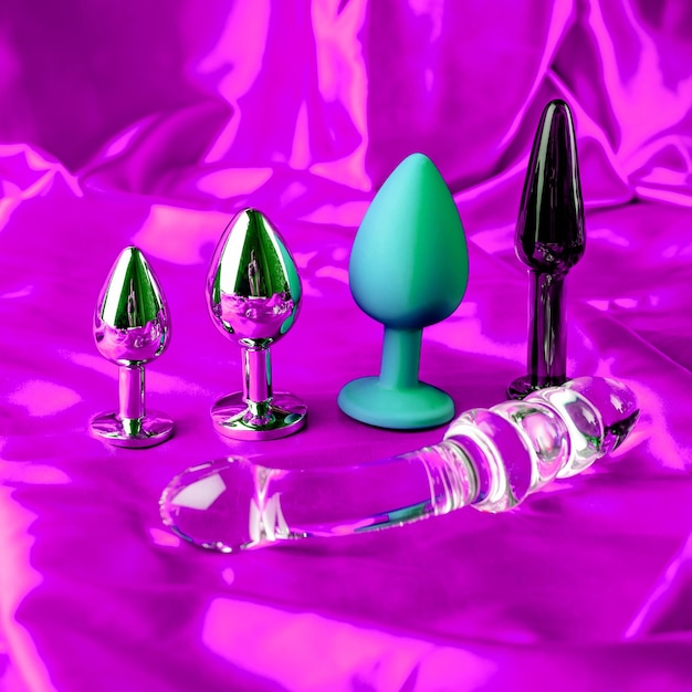 Фото Коллекция разных видов секс-игрушек на фиолетовом атласе