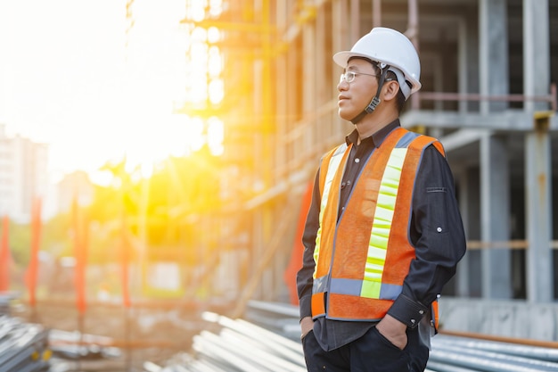 写真 建設作業員が太陽が照っている建物の前に立っています