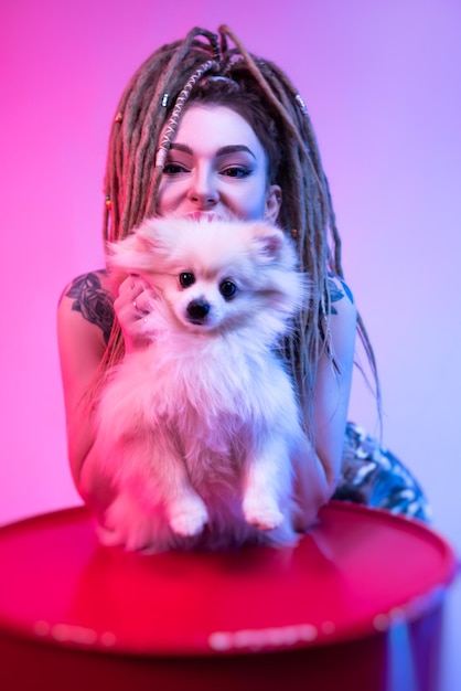 写真 ネオン照明で可愛いポメラニア犬と ⁇ のドレッドラックをかぶったカッコいい女の子