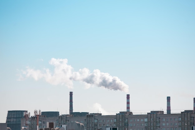 写真 青空の背景に煙のある工業用煙突のあるコピースペース。環境問題としての大気中の煙突汚染