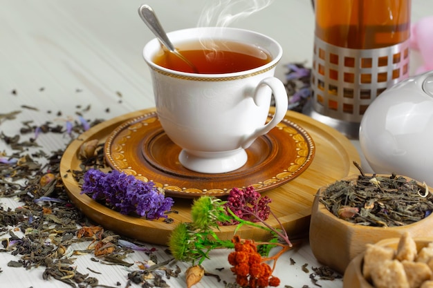 Фото Чашка чая стоит на деревянном подносе рядом с чашкой чая.