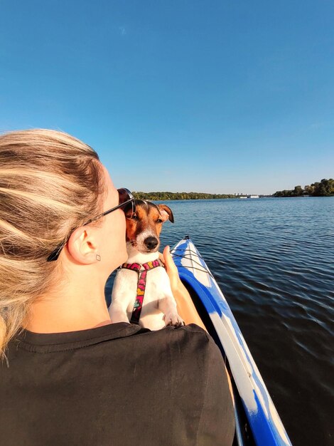 写真 ジャック・ラッセル・テリアの犬が金の女性の肩の後ろから見ている