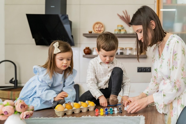A family is preparing for easter by painting easter eggs in the kitchen