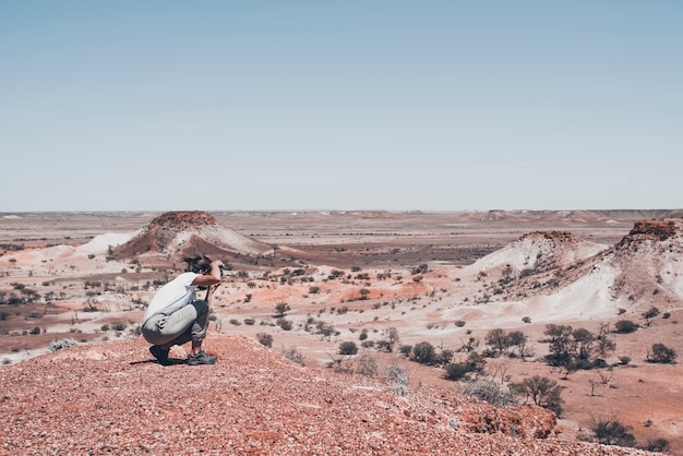 写真 女性写真家と旅行者は、壮観な砂漠の人里離れた場所で写真を撮っています