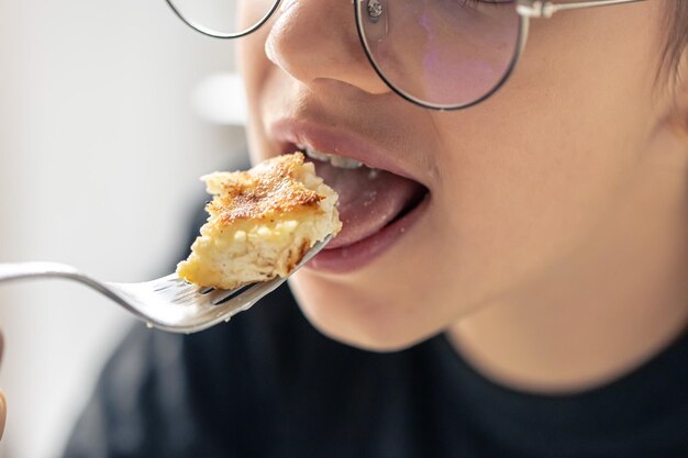 写真 女の子が口からチーズケーキを食べています ⁇