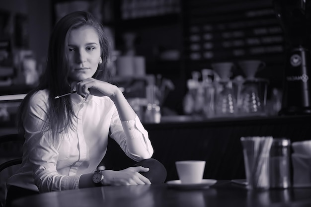 写真 カフェでコーヒーを飲んでいる女の子 レストランで朝食をとっている女性 女の子のための喫茶店で朝のコーヒー