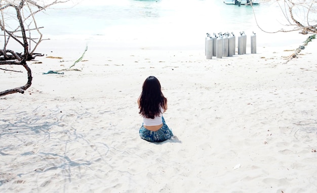 写真 真っ白な砂浜に女の子が座っている