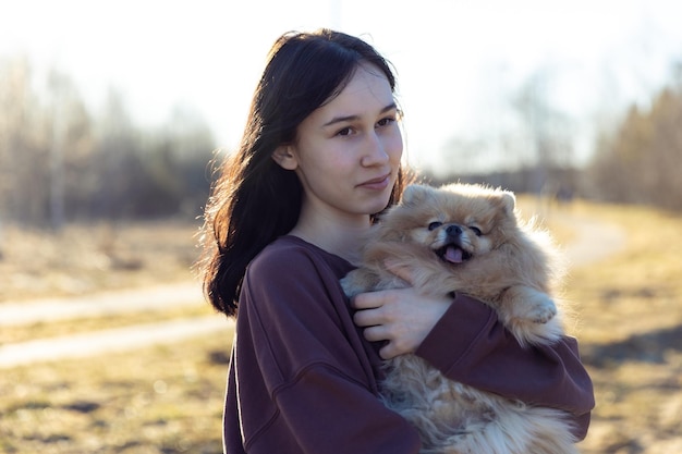 사진 한 소녀가 공원 야외 레크리에이션에서 강아지와 함께 산책하며 작은 강아지와 함께 초상화를 애완동물과 함께
