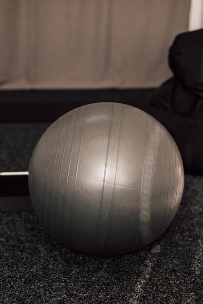 Фото Серый большой фитнес-мяч лежит в спортзале
