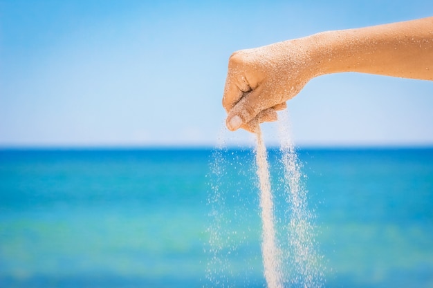 A Hands giet zand van de zee over de natuur